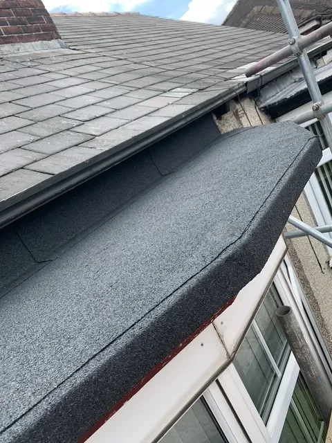 After: the same bay window roof re-covered by Wales Roofing in new mineral felt, dressed up beneath the gutter