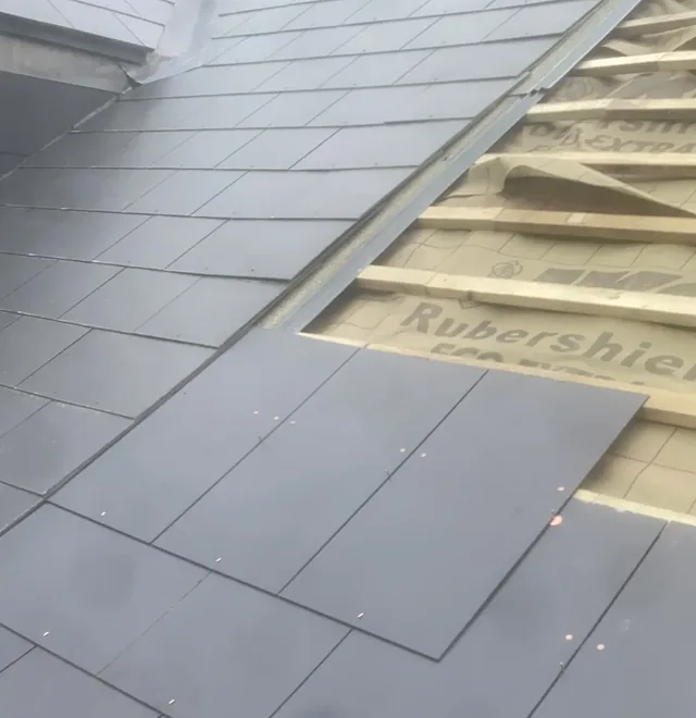 New slates being nailed over new battens and breathable membrane on a re-roof by Wales Roofing